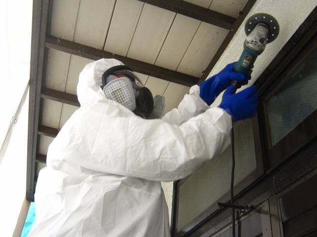 防じんマスクと保護具を着用して作業する職人